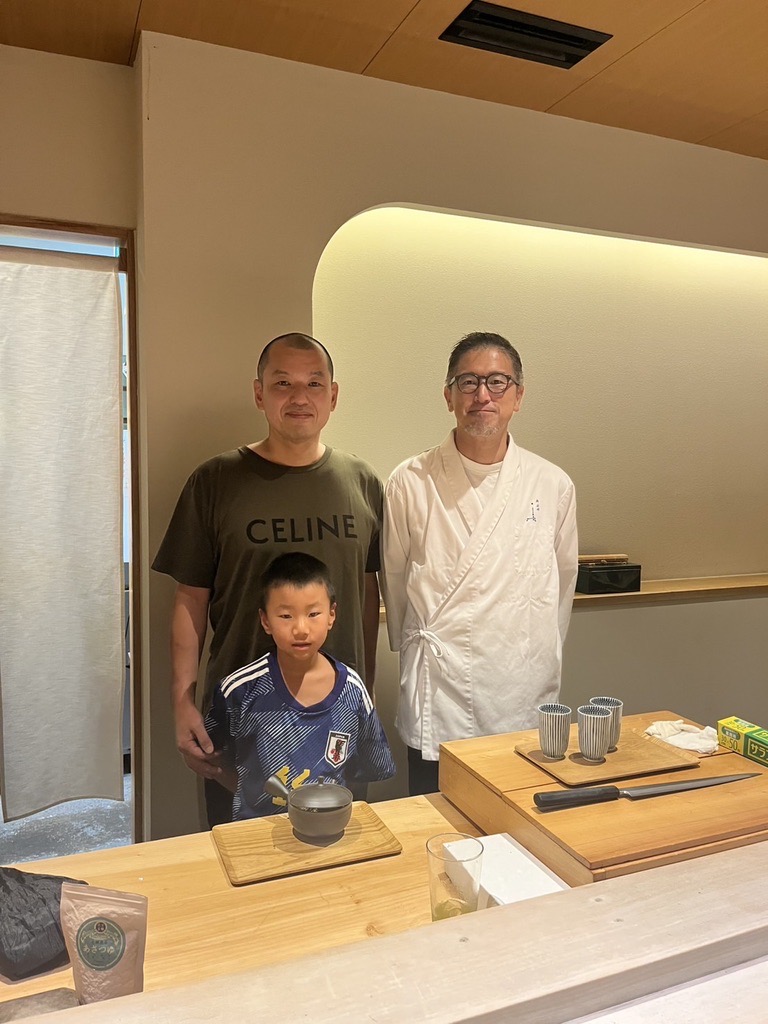 Guests with Japanese sushi chef at restaurant counter