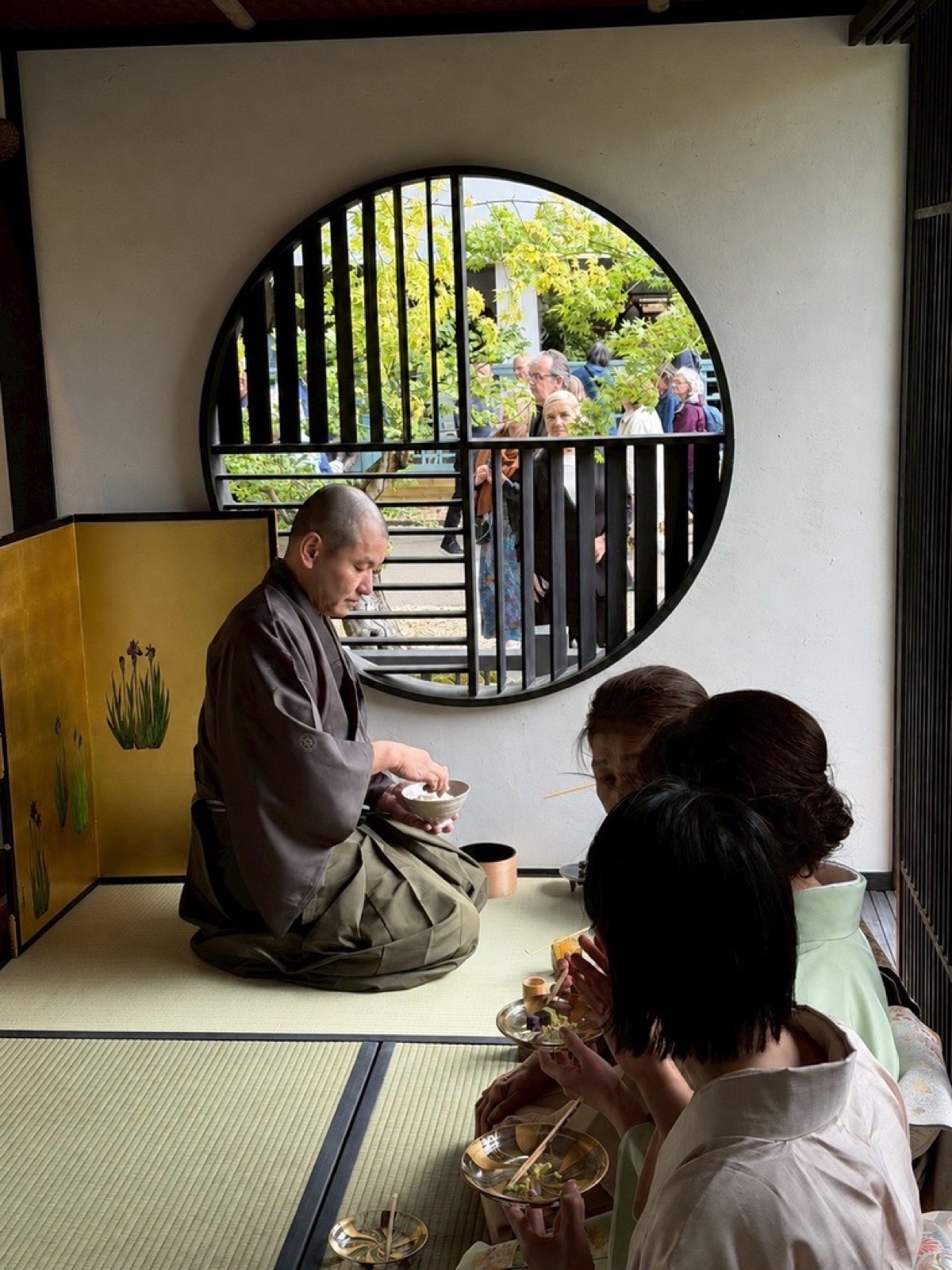 Tea gathering in a tatami room with round window